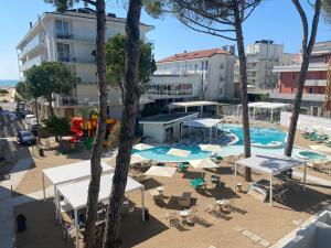 una piscina al aire libre con sillas y sombrillas en Marina Palace Hotel 4 stelle S, en Caorle