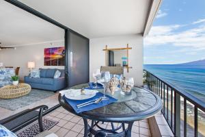 a balcony with a table and a view of the ocean at Maui Kai 504 in Kahana