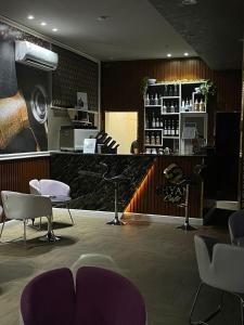 un salon avec des chaises violettes et un comptoir dans une pièce dans l'établissement Shyan Hotel, à Médine