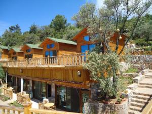 a log home with a wrap around deck at Kabak Armes Hotel in Faralya