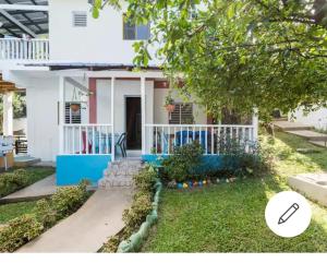 una casa con una fachada blanca y azul en Cabaña Vistas del Bosque piscina privada en Jarabacoa