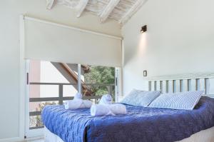 Un dormitorio con una cama azul con dos animales de peluche. en BOG Las Frutillas en Villa La Angostura
