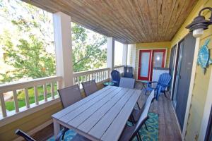 terraza con mesa de madera y sillas en el porche en Seascape-Heron Harbour 202-3 condo, en Ocean City