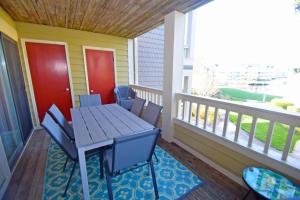 porche con mesa de madera y sillas en el balcón en Seascape-Heron Harbour 202-3 condo, en Ocean City