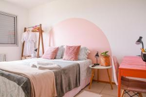 um quarto com uma cama com almofadas cor-de-rosa em Lindo Apt no Jd das Américas em Cuiabá