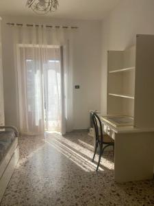 Zimmer mit einem Schreibtisch, einem Stuhl und einem Fenster in der Unterkunft Appartamento Peschici in Peschici