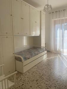 - une chambre avec un lit, des armoires blanches et une fenêtre dans l'établissement Appartamento Peschici, à Peschici