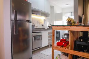 a kitchen with a stainless steel refrigerator at Lindo Apt no Jd das Américas in Cuiabá