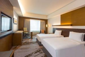 宿霧市的住宿－Radisson Blu Cebu，酒店客房配有两张床和一张书桌