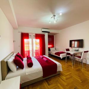 een slaapkamer met een groot bed met rode kussens bij Front Beach Exclusive Apartments in Struga