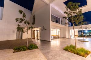 a large white building with palm trees in the middle at Radisson Blu Resort Al Hoceima in Al Hoceïma