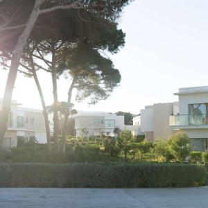 Radisson Blu Resort Al Hoceima في الحسيمة: اطلالة على بعض المباني من اشجار وشجيرات