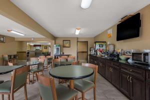 um restaurante com mesas e cadeiras e uma televisão em SureStay Plus Hotel by Best Western Silver City em Silver City