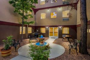 a courtyard with a fountain in front of a building at SureStay Plus Hotel by Best Western Silver City in Silver City