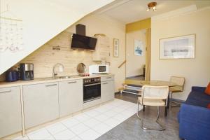 a kitchen and dining room with a table and a couch at Apartmentanlage Eldena Ferienwohnung 10 in Lobbe