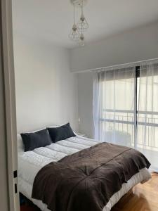 a bedroom with a large bed and a window at Cómodo dos ambientes in Buenos Aires