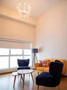 een woonkamer met een bank en 2 stoelen bij Hotel Britania Crystal Collection in Lima