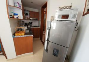 a kitchen with a refrigerator with a microwave on top of it at Apartamento en el Rodadero con vista al mar, edificio Macondo in Rodadero