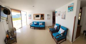 a living room with blue chairs and a couch at Apartamento en el Rodadero con vista al mar, edificio Macondo in Rodadero
