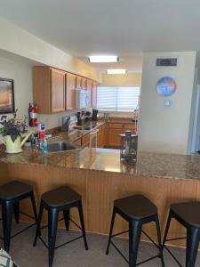 a kitchen with a counter with four stools in it at Oak Shores. in Biloxi