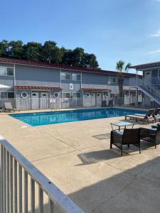 a swimming pool with two benches and a building at Oak Shores. in Biloxi