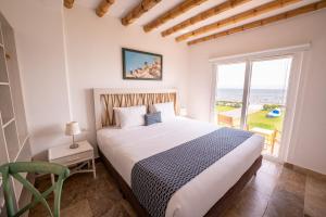 a bedroom with a large bed and a large window at Atoq Paracas Reserva in Paracas