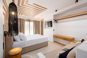 een slaapkamer met een bed en een bank bij SunSal Luxury Studios - Sky in Naousa