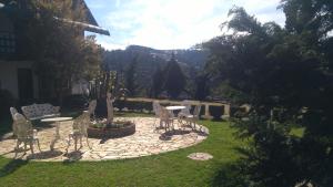 a patio with chairs and a table in a yard at Pousada Valle do Luar - Campos do Jordao in Campos do Jordão