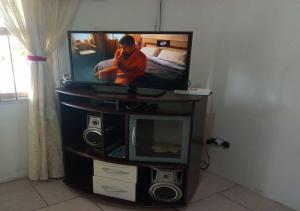 TV de pantalla plana en la parte superior de un centro de entretenimiento en Lugar perfeito para você e sua família en Río Grande