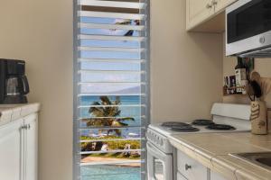 a kitchen with a window with a view of the ocean at Noelani 213 in Kapalua-West Maui Airport