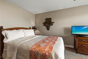 um quarto com uma cama e uma televisão de ecrã plano em Noelani 117 em Kahana