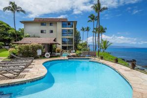 uma piscina com vista para um hotel e para o oceano em Noelani 117 em Kahana