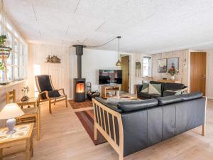 a living room with a couch and a fireplace at Holiday home Blåvand CCXXXVIII in Blåvand