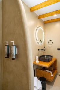 a bathroom with a sink and a toilet at SunSal Luxury Studios - Sky in Naousa