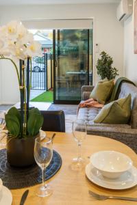 einen Esstisch mit zwei Weingläsern darauf in der Unterkunft Best of Central Christchurch 2 bed 2 bath in Christchurch