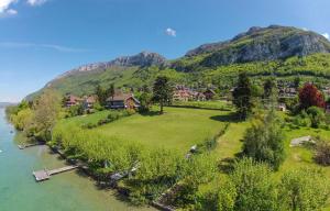 a village on the river with a mountain in the background at Studio Des Sources - Vision Luxe in Veyrier-du-Lac