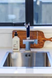 a sink with a bottle of soap sitting next to it at Best of Central Christchurch 2 bed 2 bath in Christchurch