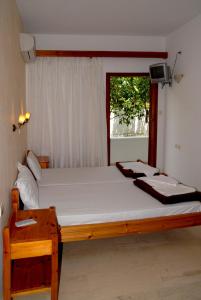 a bedroom with a large bed with a window at Pension Kyriakos in Plakias