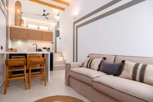 a living room with a couch and a kitchen at SunSal Luxury Studios - Earth in Naousa