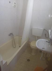a bathroom with a tub and a toilet and a sink at Aleksandros Apartments in Paralia Katerinis