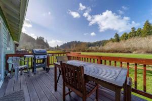 a wooden deck with a grill and a picnic table at Elk Meadow Cabins 17A Gold Rush Suite in Orick