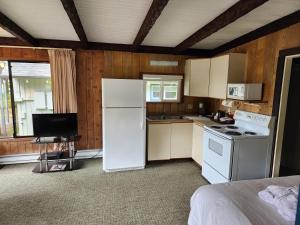 a kitchen with a white refrigerator and a stove at Ocean Crest Resort in Moclips