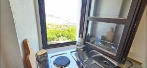 cocina con fregadero y ventana con vistas en Casa Bakara balcón de Vejer, en Vejer de la Frontera