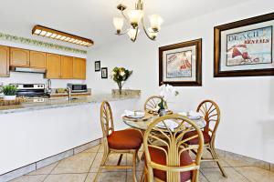 a kitchen and dining room with a table and chairs at Paki Maui 326 in Honokowai +25 photos