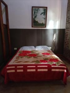 een bed met een dekbed in een slaapkamer bij Hotel Village del Sol in Puerto Iguazú