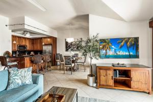 ein Wohnzimmer mit einem blauen Sofa und einer Küche in der Unterkunft Kapalua Golf Villa 25P 3&4 in Kahana