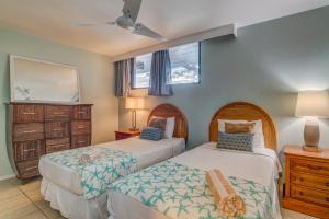 1 dormitorio con 2 camas y espejo en Paki Maui 123, en Kahana