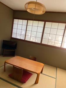 una sala da pranzo con tavolo e una grande finestra di B&B Retreat志摩 a Shima