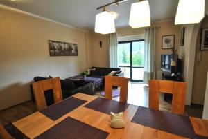 a living room with a table and a couch at Apartamenty Belweder - Sun Seasons 24 in Wisła