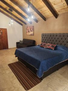 a bedroom with a blue bed and a couch at Villa Onawa by Natut Huasca in Huasca de Ocampo
